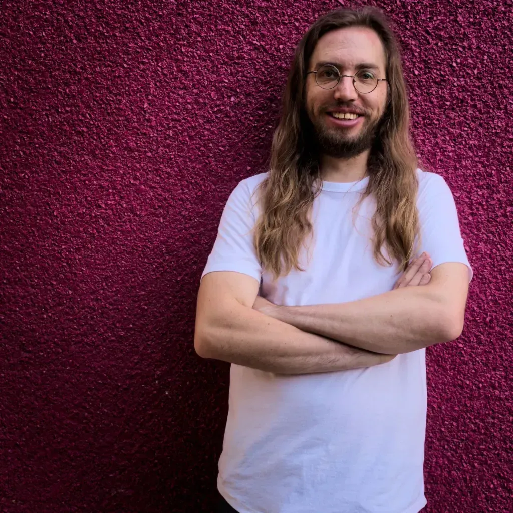 a photo of Jake against a pink wall